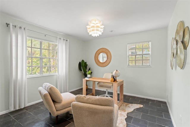 office area featuring baseboards and stone tile flooring