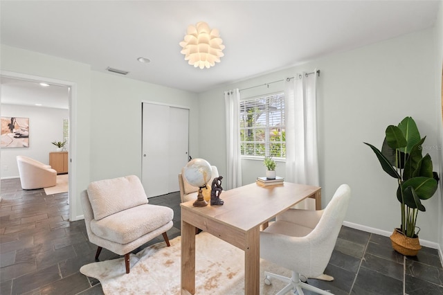 office space featuring stone tile floors, recessed lighting, visible vents, and baseboards