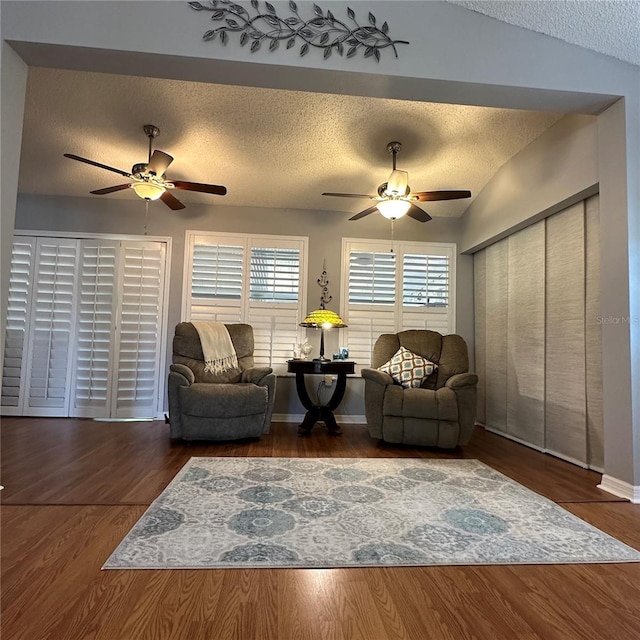 living room with wood finished floors, a textured ceiling, and ceiling fan