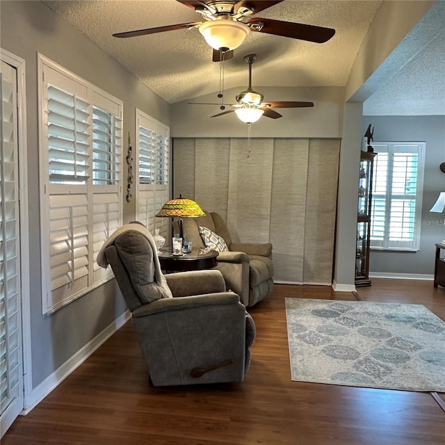 living area featuring a textured ceiling, vaulted ceiling, wood finished floors, and ceiling fan