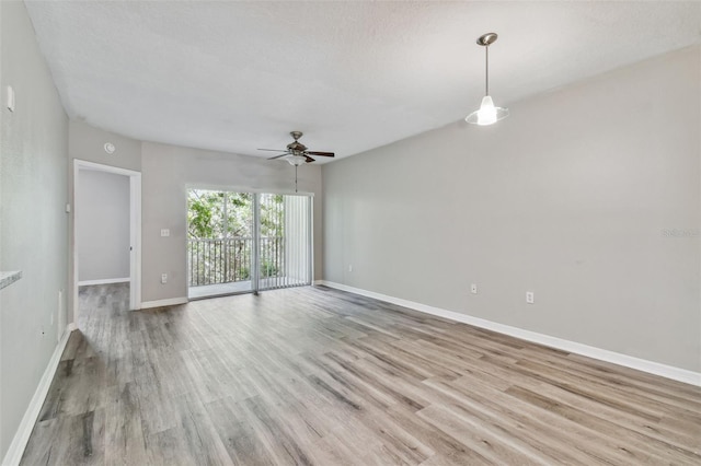 spare room with light wood-type flooring, baseboards, and ceiling fan