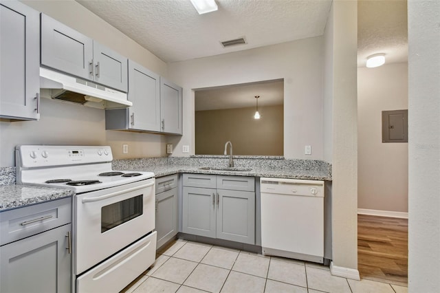 kitchen featuring visible vents, gray cabinetry, under cabinet range hood, white appliances, and a sink