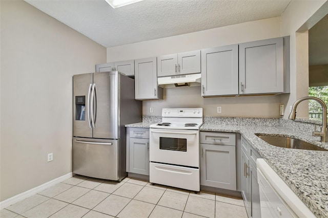 kitchen with white appliances, gray cabinets, and a sink