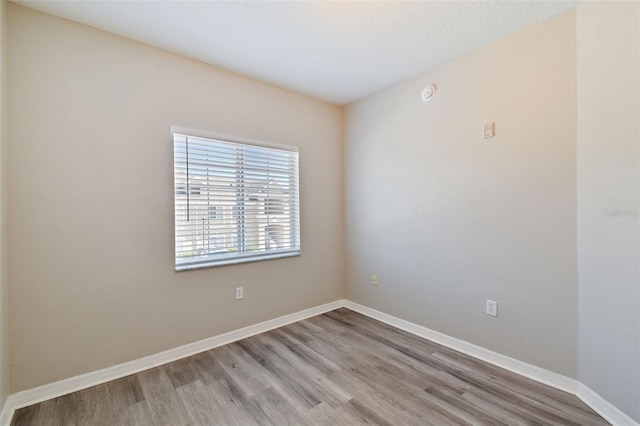 unfurnished room featuring baseboards and wood finished floors