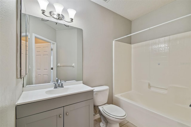 bathroom featuring tile patterned floors, toilet, a textured ceiling, washtub / shower combination, and vanity