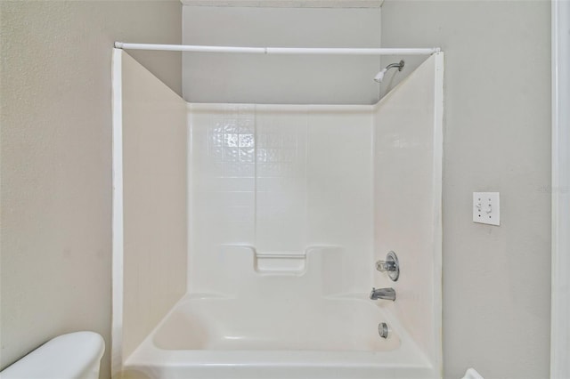 bathroom featuring shower / bathing tub combination and toilet