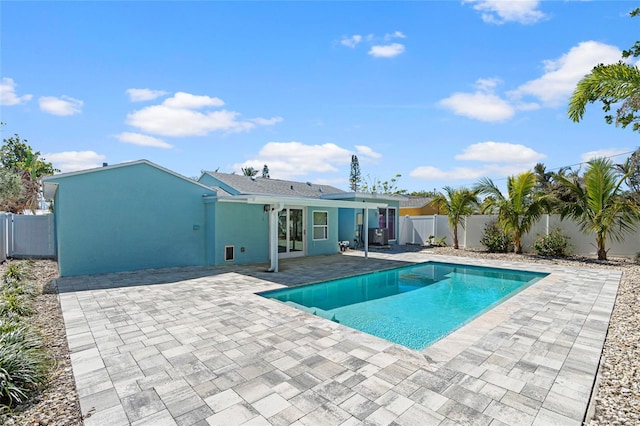 view of pool with a patio area, a fenced in pool, french doors, and a fenced backyard