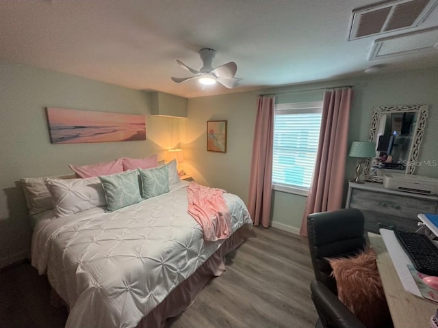 bedroom with baseboards, wood finished floors, visible vents, and ceiling fan