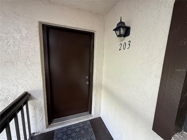 doorway to property featuring stucco siding