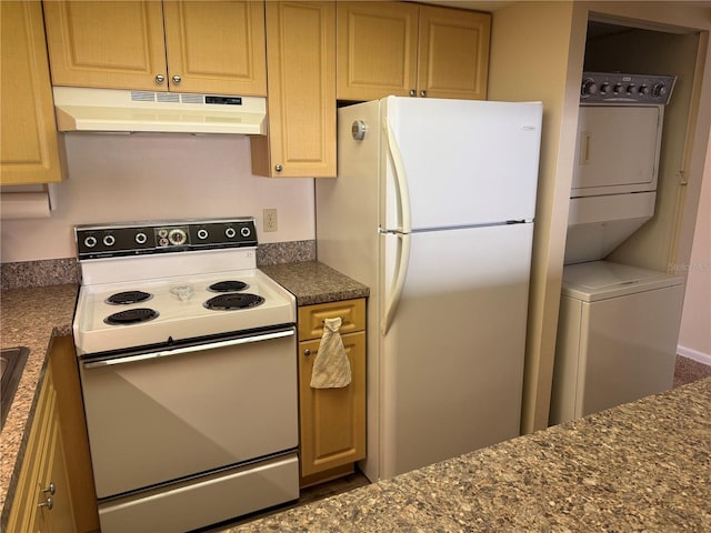 kitchen with under cabinet range hood, white appliances, and stacked washer and clothes dryer