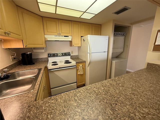 kitchen with visible vents, stacked washer and dryer, under cabinet range hood, a sink, and white appliances