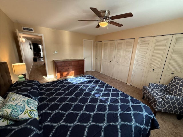 bedroom with visible vents, ceiling fan, multiple closets, and carpet floors