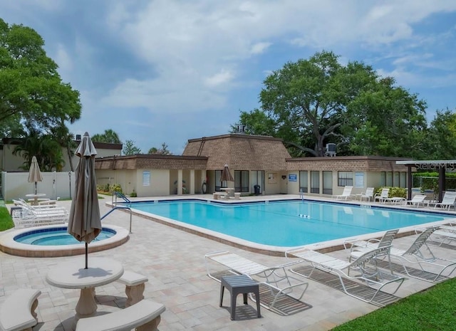 community pool with a patio, a community hot tub, and fence