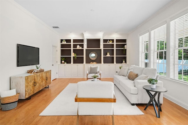 living room with visible vents, crown molding, baseboards, and wood finished floors