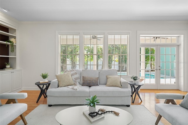 living room with french doors, crown molding, and wood finished floors