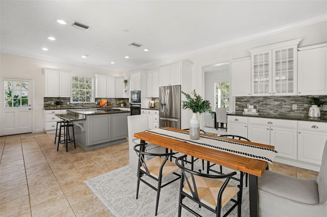 kitchen with visible vents, black appliances, a kitchen island, dark countertops, and white cabinetry