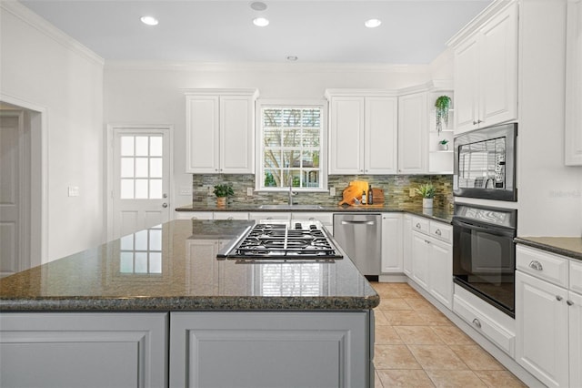 kitchen featuring white cabinets, a healthy amount of sunlight, a kitchen island, and stainless steel appliances