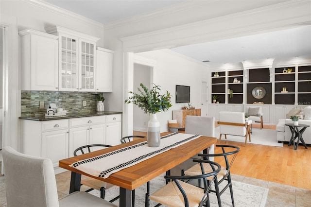 dining area with light wood-type flooring and ornamental molding