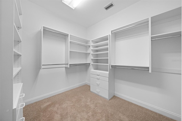 walk in closet featuring visible vents and light colored carpet