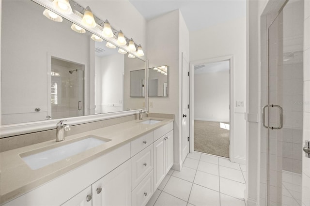 bathroom with a sink, a stall shower, double vanity, and tile patterned flooring