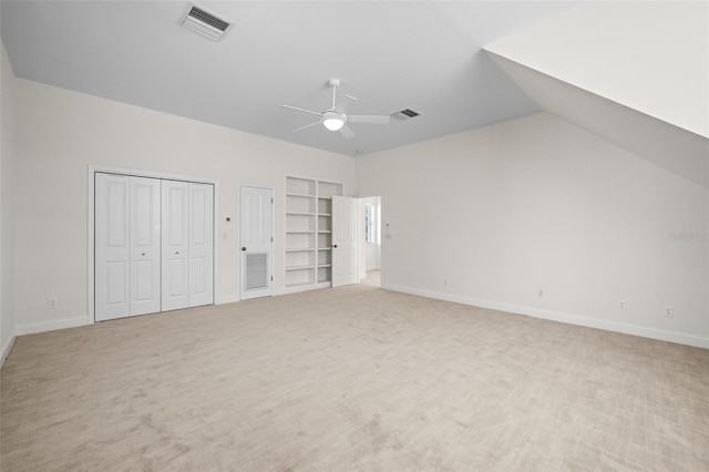 unfurnished bedroom featuring visible vents, light colored carpet, two closets, and baseboards