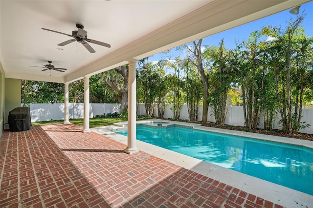 view of swimming pool featuring ceiling fan, a patio, a pool with connected hot tub, and a fenced backyard