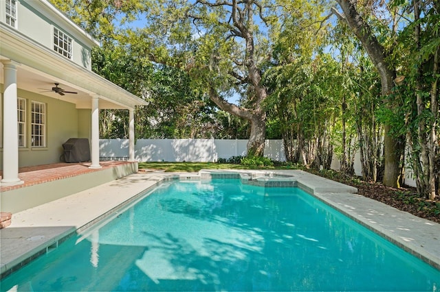 view of swimming pool with a pool with connected hot tub, a fenced backyard, a grill, ceiling fan, and a patio area