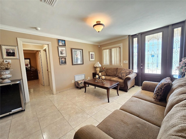 living room featuring crown molding, light tile patterned floors, baseboards, and visible vents