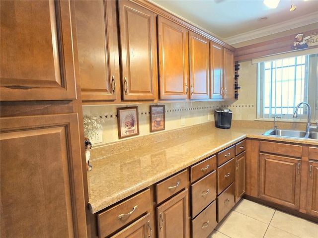 kitchen with light tile patterned flooring, ornamental molding, brown cabinets, and a sink