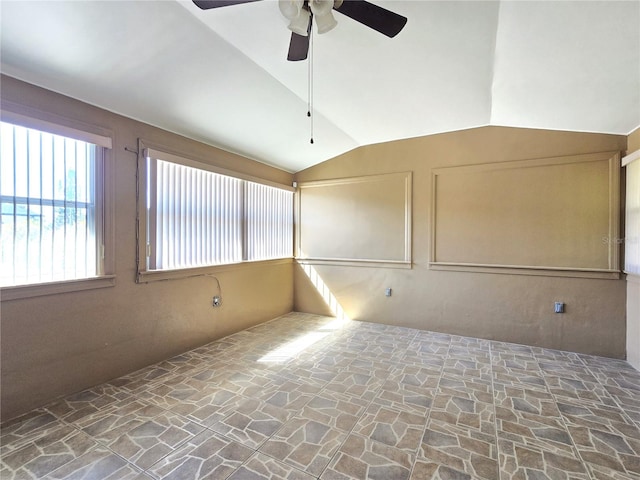 spare room with stone finish floor, lofted ceiling, and ceiling fan