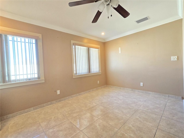 tiled spare room featuring visible vents, baseboards, and ornamental molding