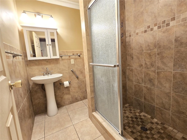 bathroom with a stall shower, ornamental molding, a sink, tile walls, and tile patterned flooring