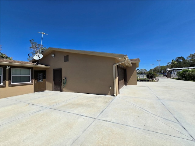 exterior space with stucco siding and a patio area