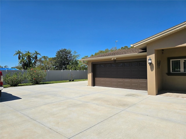 garage with driveway and fence