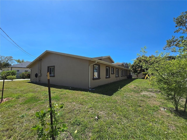 view of property exterior with a lawn and stucco siding