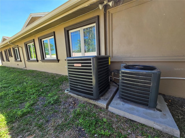 exterior details with stucco siding and central AC