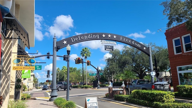 view of street with traffic signs, sidewalks, traffic lights, curbs, and street lighting