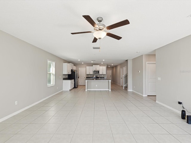 unfurnished living room with light tile patterned floors, a ceiling fan, baseboards, recessed lighting, and a sink