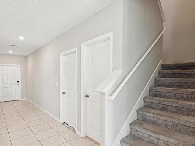 staircase with tile patterned floors, visible vents, recessed lighting, and baseboards