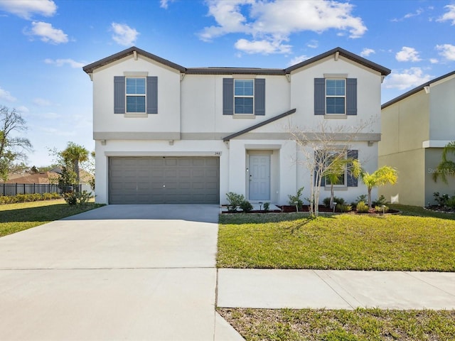 view of front of house with a front lawn, fence, concrete driveway, stucco siding, and an attached garage