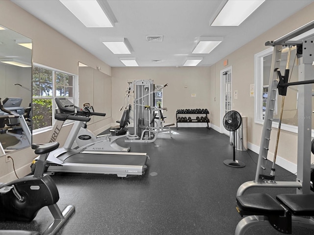 exercise room with baseboards and visible vents