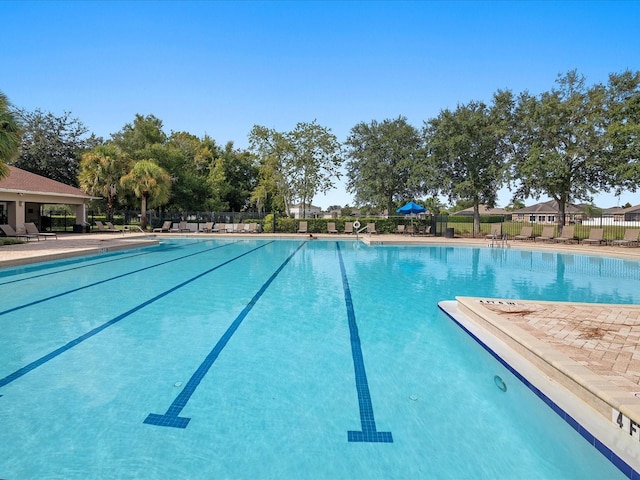 community pool with a patio and fence