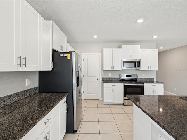 kitchen with white cabinets, light tile patterned flooring, and appliances with stainless steel finishes