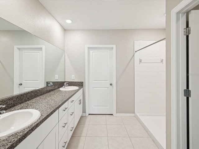 bathroom with tile patterned floors, a tile shower, and a sink