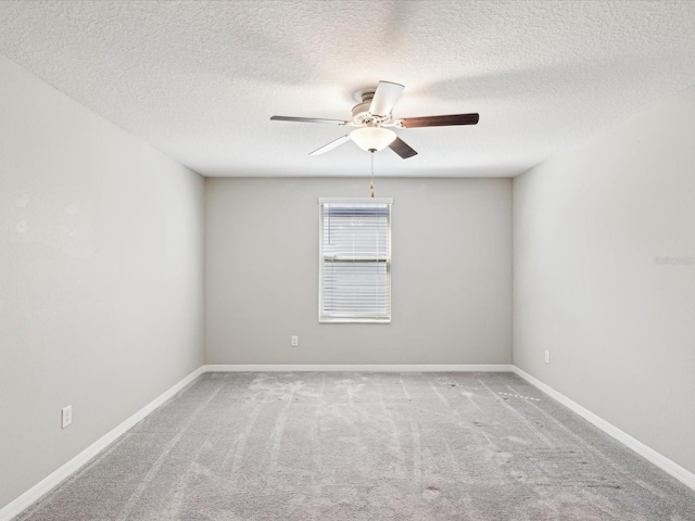 spare room with a textured ceiling, baseboards, a ceiling fan, and carpet floors