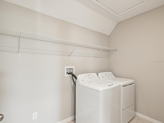 clothes washing area featuring baseboards, separate washer and dryer, and laundry area