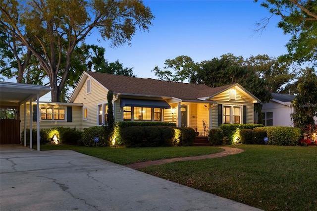 ranch-style home featuring a front yard, a carport, and driveway