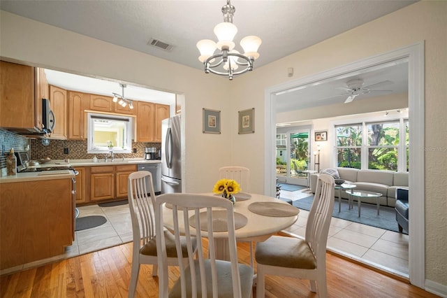 dining room featuring visible vents, plenty of natural light, and light wood-style flooring