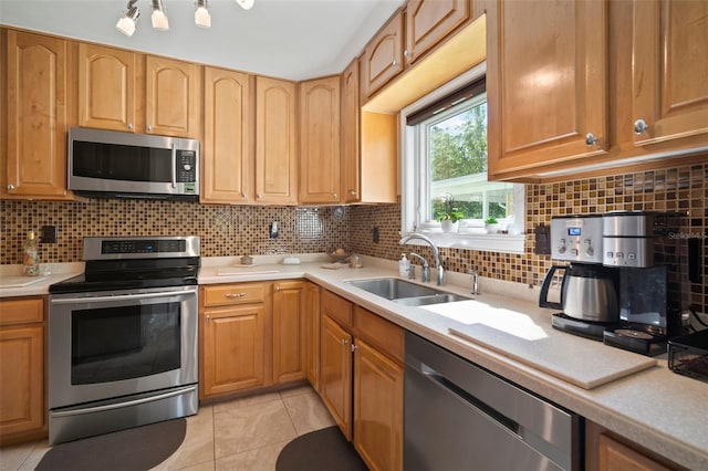 kitchen featuring tasteful backsplash, appliances with stainless steel finishes, light countertops, and a sink