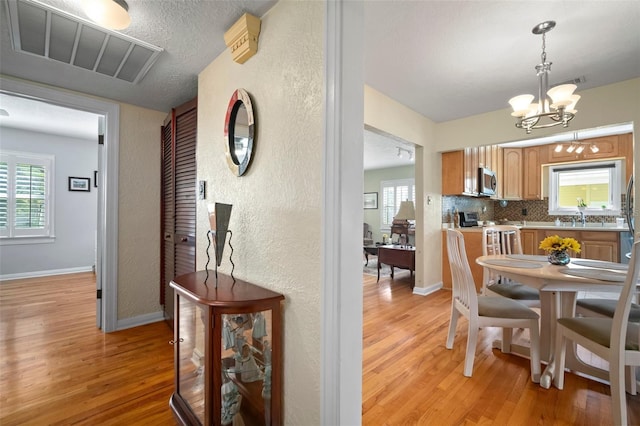 dining room with visible vents, plenty of natural light, baseboards, and light wood-style floors